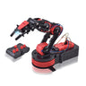 The Boeing Stores OWI Robot Arm Edge - Wireless, a red and black advanced robotic arm with a claw, is showcased on a shiny surface. It includes a matching remote control featuring multiple red switches for precise operations.