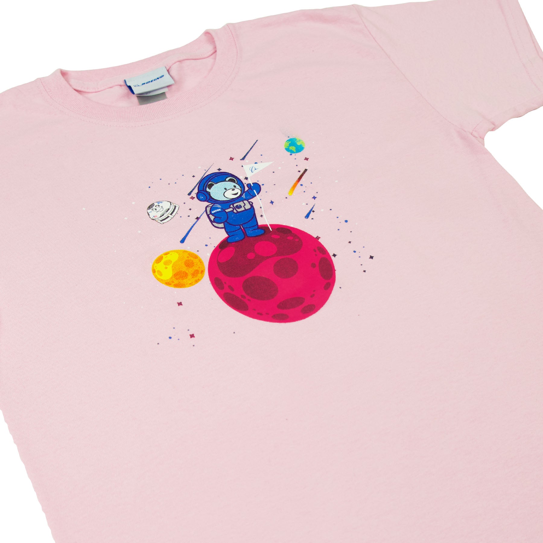 Introducing the Boeing Bear Kids T-Shirt from The Boeing Store: a pink tee featuring a cute astronaut illustration on a red planet, twinkling stars, a yellow planet with Space Explorers soaring by, and Earth in the background. Perfect for little space adventurers!.