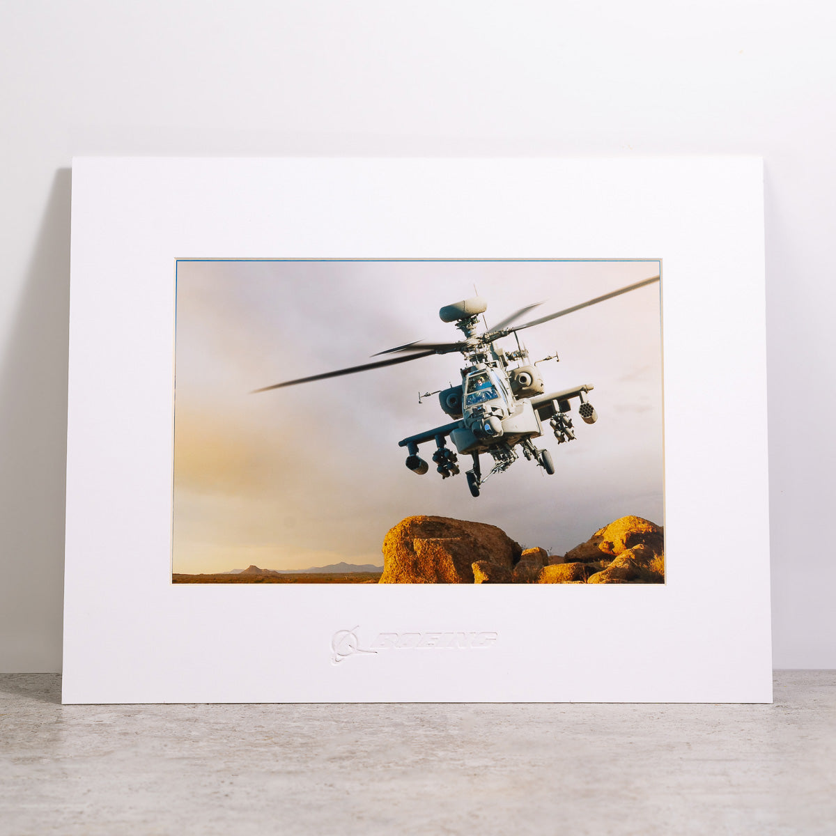 The Boeing AH-64 Apache Matted Print - Large from The Boeing Store features high-resolution digital printing of the iconic helicopter and comes in a matted frame embossed with a Boeing logo.